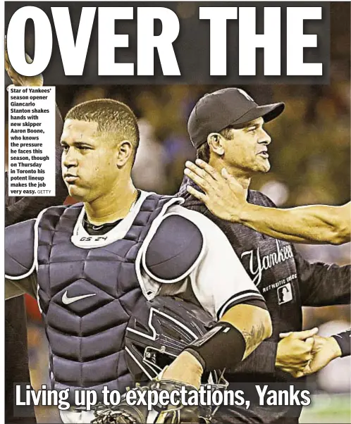  ??  ?? Star of Yankees’ season opener Giancarlo Stanton shakes hands with new skipper Aaron Boone, who knows the pressure he faces this season, though on Thursday in Toronto his potent lineup makes the job very easy.