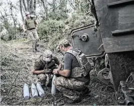  ?? TYLER HICKS The New York Times, file ?? Ukrainian soldiers handle artillery shells in the Bakhmut region on Aug. 28, 2023. Ukraine’s president signed a law this month lowering the military draft age to 25 from 27.