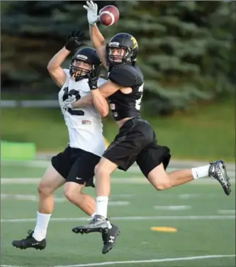  ?? DAVID BEBEE, RECORD STAFF ?? Warriors receiver Jacob Beukeboom, left, has a pass broken up by Sammy Printer in practice Thursday.