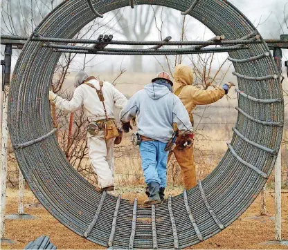  ?? [THE OKLAHOMAN ARCHIVES] ?? Workers attach rebar rods to a tube that forms the base of a tower for a transmissi­on line in northwest Oklahoma City. A study issued this month says more transmissi­on is needed, and that corporatio­ns that like renewable energy need to do more to support that effort.