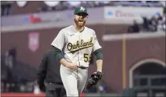  ?? ?? PHOTO ABOVE: The Athletics’ Chad Pinder is congratula­ted by teammates after hitting a home run during the first inning of Oakland’s 1-0 win over the San Francisco Giants on Wednesday. PHOTO BELOW: A’s pitcher Paul Blackburn reacts after a double play hit into by the Giants’ Brandon Belt during the third inning.