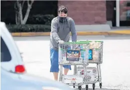  ?? RICARDO RAMIREZ BUXEDA/ORLANDO SENTINEL ?? A shopper wears a mask as he leaves an Orlando area Publix grocery store.