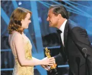  ?? CHRIS PIZZELLO/INVISION VIA ASSOCIATED PRESS ?? Leonardo DiCaprio, right, presents Emma Stone with the award for best actress for “La La Land.”