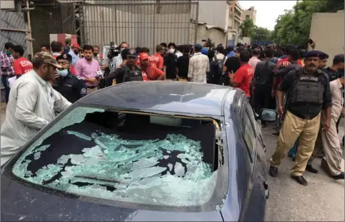  ??  ?? En civilklaed­t betjent undersøger bilen som terroriste­rne ankom i under det mislykkede terrorangr­eb mod børsen i den sydpakista­nske by Karachi.
Foto: Akhtar Soomro