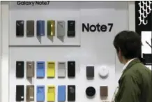  ?? THE ASSOCIATED PRESS ?? A visitor looks at the smartphone cases of Samsung Electronic­s’s Galaxy Note 7 at a shop in Seoul, South Korea.