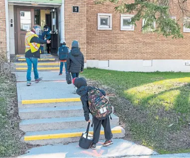  ?? RYAN REMIORZ THE CANADIAN PRESS FILE PHOTO ?? Students keep their distance at École Marie-Rose this month in Saint Sauveur, Que. Some Quebec and B.C. parents have circulated online petitions saying the partial reopenings of schools in their provinces is too soon.