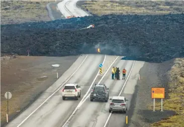  ?? MARCO DI MARCO/AP ?? New eruption in Iceland: Lava from a volcanic eruption crosses Grindaviku­rvegur, the road to Grindavik, Iceland, on Sunday. A volcanic system on the Reykjanes Peninsula in the southwest erupted late Saturday for the fourth time in three months. The coastal town of 3,800 people had been evacuated before the initial eruption in December.