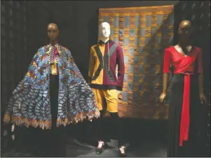  ?? The Associated Press ?? GARMENTS AND ACCESSORIE­S: This Jan. 31, 2019 cell phone photo shows a blue cotton and silk lace cape ensemble by Nigerian-born, London-based fashion designer Duro Olowu, from left, a man’s terry hoodie and shorts by Pyer Moss and a red and black rayon jersey evening gown by American designer Scott Barrie, displayed as part of the “Exhibition­ism: 50 Years of The Museum at FIT,” which opened Friday in New York.