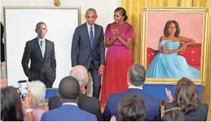  ?? ANDREW HARNIK/ASSOCIATED PRESS ?? Former President Barack Obama and former first lady Michelle Obama react after unveiling their official White House portraits during a ceremony Wednesday in the East Room of the White House. His is by artist Robert McCurdy, and hers was created by Sharon Sprung.