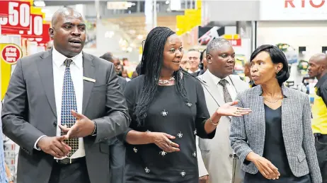  ??  ?? LEADING THE CHARGE: Massbuild’s regional operations manager, Peter Mamabolo, left, walks through the new Builders Warehouse store with Margaret Mhango Mwanakatwe, Zambia’s minister of commerce, trade and industry, centre, and, far right, permanent...