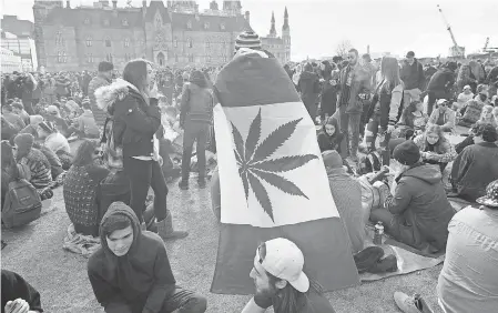  ??  ?? A man wearing a Canadian maple leaf flag with a marijuana leaf takes part in the annual 4/20 rally on Parliament Hill in Ottawa, Ontario, on April 20. LARS HAGBERG/GETTY IMAGES