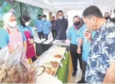  ?? ?? Yakub tasting one of the seafood products produced by a course participan­t.