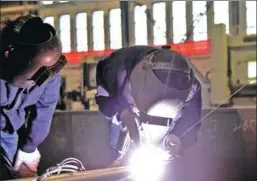  ?? PHOTOS BY SONG WEI / CHINA DAILY ?? Huang Chunyan (right) welds while trainee Zhang Yin looks on at Brainware Chang’an Electronic­s in Lu’an, Anhui province.