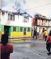  ?? PHOTO BY RICHARD MORAIS ?? Firefighte­rs attempt to put out a blaze at the popular 45year-old Hosang Restaurant and a nearby building on Market Street in Falmouth, Trelawny, yesterday.