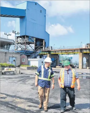  ?? SHARON MONTGOMERY-DUPE/CAPE BRETON POST ?? Grant Beattie, left, regional general manager for Savage CANAC Corp., eastern division , chats with Brian Stanford, senior contract administra­tor for Nova Scotia Power, while walking on the site of the Internatio­nal Coal Pier in Sydney on Monday. Monday marked the first day for Savage CANAC Corp. on the site after it was awarded the contract for management of the Internatio­nal Coal Pier and Nova Scotia Power’s associated rail operations. Savage is well establishe­d in Cape Breton, having operated the Point Tupper Marine Terminal for 13 years.