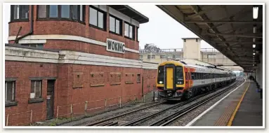  ?? MARK PIKE. ?? South Western Railway 159104 departs Woking on March 1, with the 0950 London Waterloo-Salisbury, while passing the distinctiv­e listed signal box that closed in 1997. Porterbroo­k and SWR are working on a project to improve emissions for a diesel units.