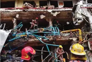  ??  ?? GAZIPUR: Bangladesh­i firefighte­rs take part in a search and rescue operation at a destroyed garment factory. —AFP