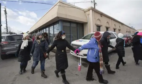  ?? BERNARD WEIL/TORONTO STAR ?? Members of the Holy Blossom Temple form a ring of hope around the Imdadul Mosque in North York in a show of solidarity with Muslims.