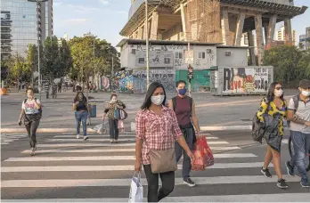  ?? VICTOR MORIYAMA/THE NEW YORK TIMES ?? Pedestrian­s wear masks June 22 in São Paulo, Brazil. European Union officials are racing to agree on who can visit the bloc as of July 1 based on how countries of origin are faring with new coronaviru­s cases. Americans and Brazilians are to be excluded, according to draft lists seen by The New York Times.