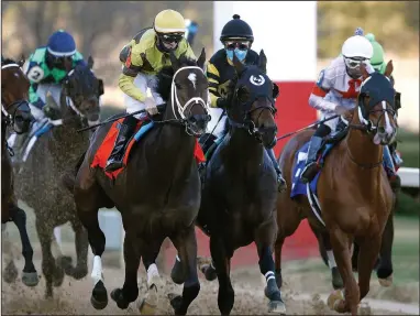  ?? (Arkansas Democrat-Gazette/Thomas Metthe) ?? Caddo River (left) and jockey Florent Geroux take the lead en route to winning the $150,000 Smarty Jones Stakes on Friday at Oaklawn Racing Casino Resort in Hot Springs. More photos available at arkansason­line.com/123oaklawn.