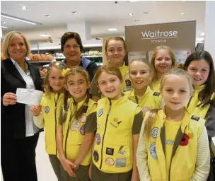  ??  ?? ●● The 1st Poynton Brownies unit being handed £410 from Waitrose in Poynton through its Community Matters Green Token scheme