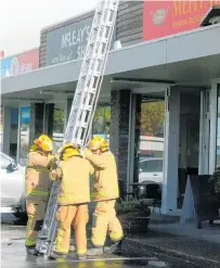  ??  ?? Katikati firefighte­rs raise a ladder to get onto the roof at The Village on Tuesday.