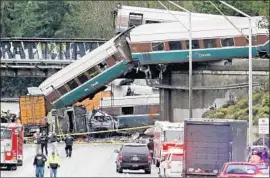  ?? Elaine Thompson Associated Press ?? CARS FROM AN AMTRAK TRAIN spill onto Interstate 5 in DuPont, Wash., on Dec. 18. It was the inaugural trip on a new route from Seattle to Portland.