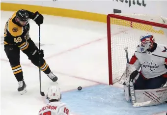  ?? NAncy lAnE pHOTOS / HErAld STAff ?? LIGHT THE LAMP: David Krejci redirects the puck past Vitek Vanecek in the first period for the first of two goals on Sunday afternoon.