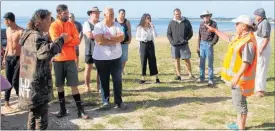  ??  ?? DoC ranger Shayne Storey telling volunteers what to do if the dolphins returned to the beach on Friday.