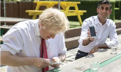  ?? Photograph: Heathcliff O'Malley/Getty Images ?? Boris Johnson, then the PM, and his chancellor Rishi Sunak use their phones during a visit to a London pizza restaurant preparing to open post-lockdown in June 2020.