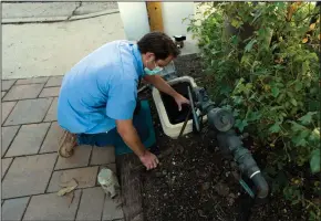  ?? (AP/Jae C. Hong) ?? Cason Gilmer, a senior field customer service representa­tive from the Las Virgenes Municipal Water District, installs an advanced water metering system in Agoura Hills, Calif., earlier this month.