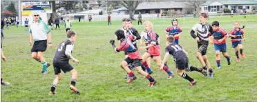  ??  ?? Cayden Pardy (Pahiatua School) heading for the tryline in the junior rugby division.