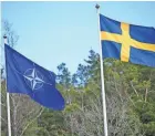  ?? FREDRIK SANDBERG/TT NEWS AGENCY/AFP ?? The NATO flag, left, is raised next to a Swedish flag at a ceremony in Stockholm on Monday.