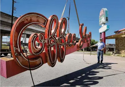  ?? Photos by Kin Man Hui/staff photograph­er ?? Mike Ryan of Texas Neon & LED Sign Co. works Monday to rig up the removal of the Pig Stand’s “Coffee Shop” neon sign for vintage sign collector Clifton Jones of Austin after the iconic business closed for good over the weekend.