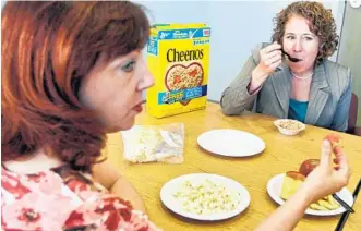  ?? CARLINE JEAN/STAFF PHOTOGRAPH­ER ?? Beth Levine, left, and Danielle Hartman, of the Ruth Rales Jewish Family Service, eat breakfast from their $31.50 a week food stamp budget.