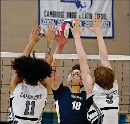  ?? (STUART CAHILL/BOSTON HERALD ?? Lexington’s Matteo Luciani fires the ball into CRL’s Reddy Montalvo-Lugo (L) and Jay Rochberg (R) as Cambridge Rindge & Latin takes on Lexington in boys volleyball on May 26, 2023 in, Cambridge, MA.