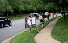  ?? AP ?? Activists hold signs as the motorcade for President Donald Trump departs Trump National Golf Club.