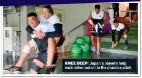  ??  ?? KNEE DEEP: Japan’s players help each other out on to the practice pitch