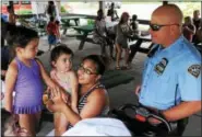  ?? JOHN STRICKLER — DIGITAL FIRST MEDIA ?? Pottstown Police Department K-9 officer Jeffrey Portock talks with Stephanie Moore and children Caleigh, Bailey and Alivia about his K-9 partner Taz. The K-9 team put on a demonstrat­ion for children attending the Pottstown Parks and Recreation camp...