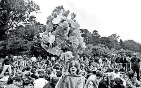  ?? TED STRESHINSK­Y PHOTOGRAPH­IC ARC/CORBIS ?? A boy carries paper flowers on a pole at a 1967 summer solstice celebratio­n at Golden Gate Park in San Francisco.