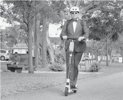  ?? CARLINE JEAN/SUN SENTINEL ?? Greater Fort Lauderdale Chamber president Dan Lindblade rides an e-scooter he rented to a downtown Fort Lauderdale meeting.