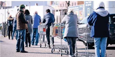  ?? FOTO: DPA ?? Lange Schlangen vor Supermärkt­en – wie hier in Berlin – wollen die Einzelhänd­ler in NRW an den Tagen vor Ostern verhindern.