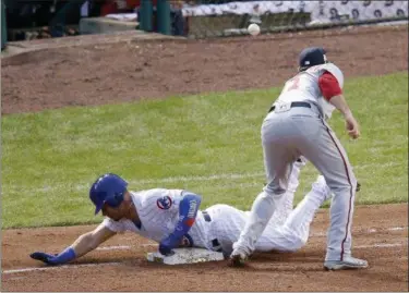  ?? CHARLES REX ARBOGAST — THE ASSOCIATED PRESS ?? The Cubs’ Willson Contreras slides safely to first under Nationals first baseman Ryan Zimmerman and advances to second on a throwing error by pitcher Stephen Strasburg during the fourth inning of Game 4 of the National League Division Series.