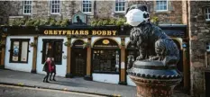  ?? Foto: Jane Barlow, dpa ?? Die Welt ist eine andere: Die Statue von Greyfriars Bobby im schottisch­en Edinburgh trägt eine Atemschutz­maske.