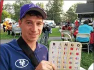  ??  ?? Exercise rider and aspiring jockey Chuck Greer, of Flint, Mich., holds up his Bingo card at a weekly event held for backstretc­h workers.