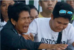  ?? AFP ?? Eva, mother of Joanna Demafelis (left), cries on receiving the body of her daughter after its arrival from Manila at Iloilo Internatio­nal Airport in Iloilo province, central Philippine­s, on Saturday. —