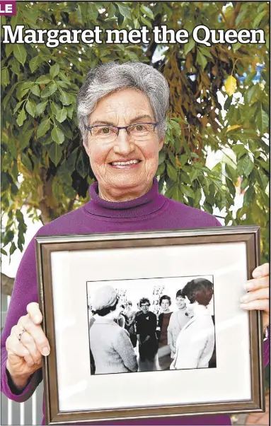  ?? PHOTO: WENDY MERRICK ?? Margaret Berry holds a cherished photo of the day she met Queen Elizabeth II at Windsor. The framed photo features the Queen at far left, and Margaret, second from the right, together with her friends Judy Nicholls and Denise Bullen.