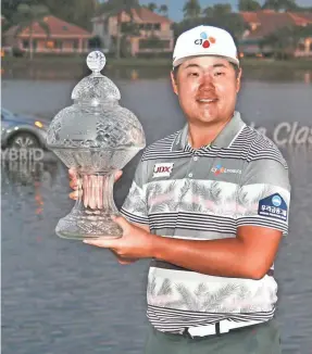  ?? REINHOLD MATAY/USA TODAY SPORTS ?? Sungjae Im holds up the champion’s trophy after winning the Honda Classic at PGA National (Champion).