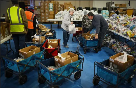  ?? HYOUNG CHANG — THE DENVER POST ?? Volunteers sort and box foods at Tri-city Baptist Food Bank in Westminste­r on Tuesday. Volunteers served about 400 families.