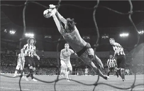  ?? DARREN STAPLES / REUTERS ?? Newcastle United’s Tim Krul saves a header from Manchester City’s Edin Dzeko (center) during their English Premier League match at Etihad Stadium in Manchester on Monday. City won 4-0.